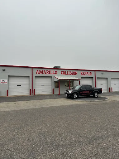 The Amarillo Collision Repair shop, a white building with red trim and five bay doors.